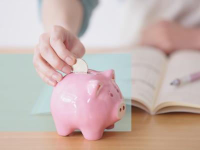 Sparegris og hånd med penge