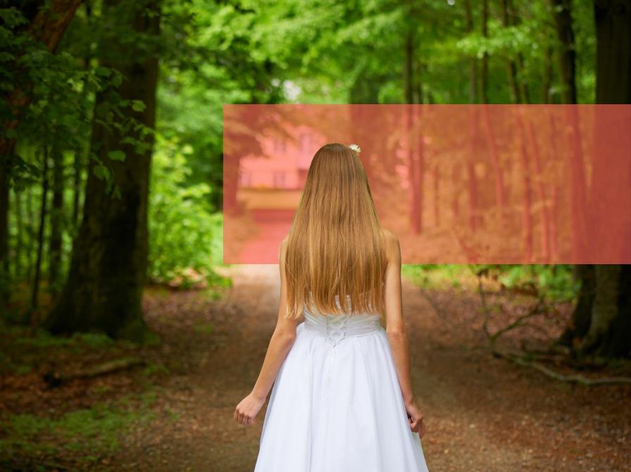 Konfirmand i hvid kjole på vej i bøgeskov